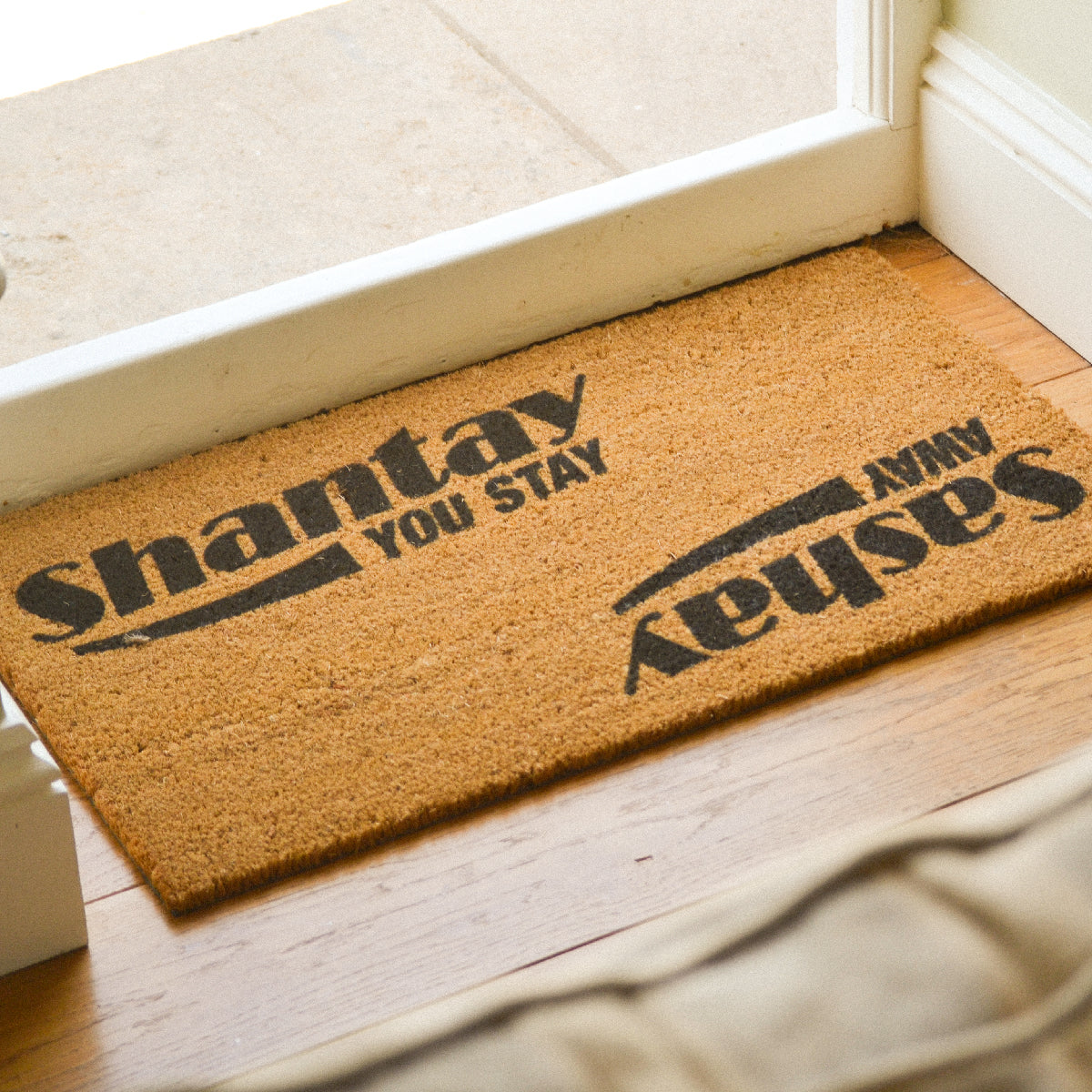 Coir doormat with RuPaul saying 'Shantay you stay, Sashay Away' printed on in it with black ink